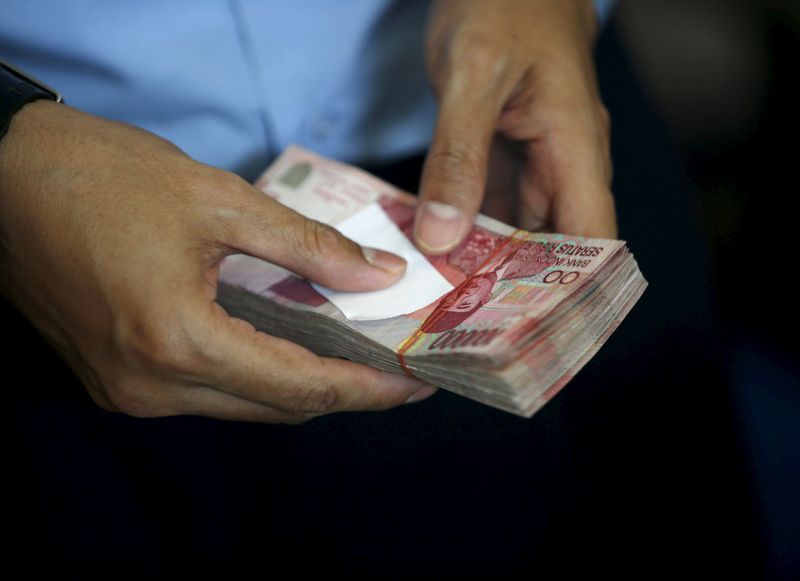 &copy; Reuters. FILE PHOTO: A Bank Indonesia employee holds Indonesian rupiah bank notes at the bank's headquarters in Jakarta, Indonesia December 16, 2015.REUTERS/Darren Whiteside