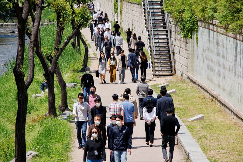 &copy; Reuters. FILE PHOTO: People wear masks to prevent the spread of the coronavirus disease (COVID-19) as they take a walk on a sunny spring day in Seoul, South Korea, May 3, 2022.  REUTERS/ Heo Ran