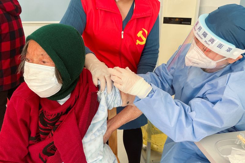 &copy; Reuters. Una sanitaria administra una dosis de vacuna contra la enfermedad por coronavirus (COVID-19) a un anciano residente, durante una visita organizada por el Gobierno a un centro de vacunación en la aldea de Zhongmin, a las afueras de Shanghái, China. 21 de