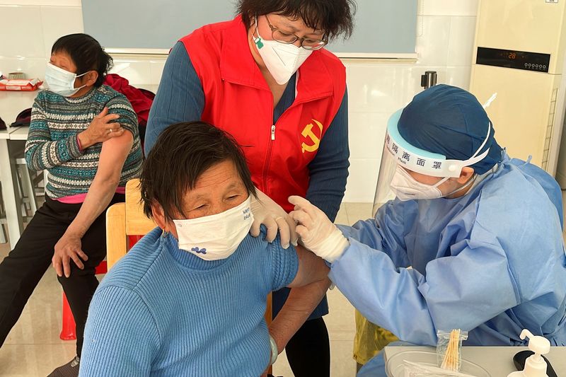 &copy; Reuters. عامل طبي يعطي رجل مسن جرعة من لقاح فيروس كورونا في شنغهاي بالصين يوم الأربعاء. تصوير: بريندا جوه - رويترز.