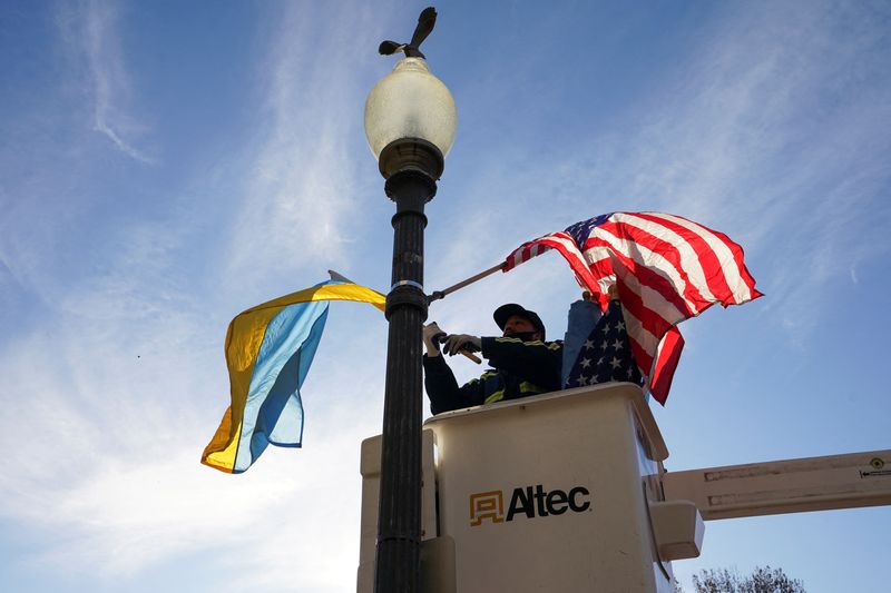 © Reuters. A worker installs Ukrainian and U.S. flags along Pennsylvania Avenue ahead of a visit by Ukraine's President Volodymyr Zelenskiy for talks with U.S. President Joe Biden and an address to a joint meeting of Congress in Washington, U.S., December 21, 2022. REUTERS/Kevin Lamarque