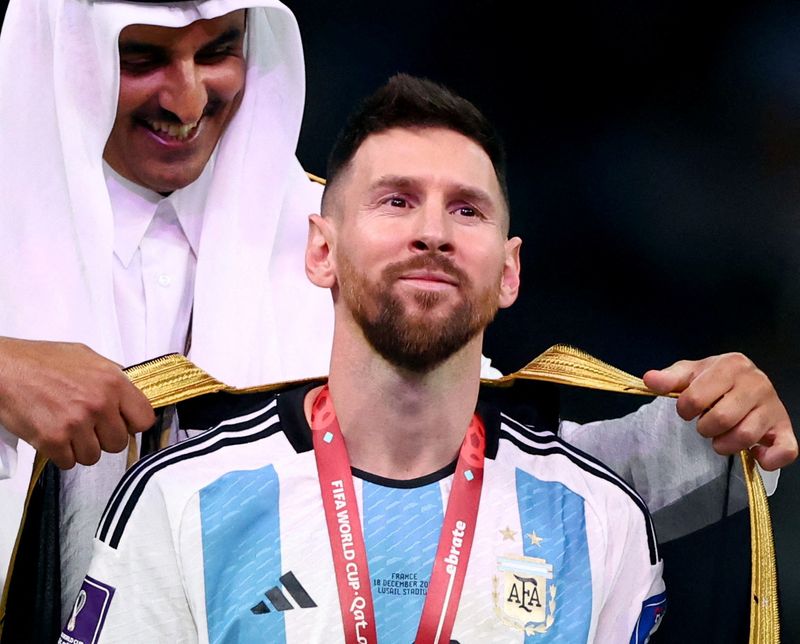 &copy; Reuters. Emir do Catar, Tamim bin Hamad Al Thani, coloca manto em Lionel Messi antes de entrega do troféu da Copa do Mundo
18/12/2022 REUTERS/Hannah Mckay  