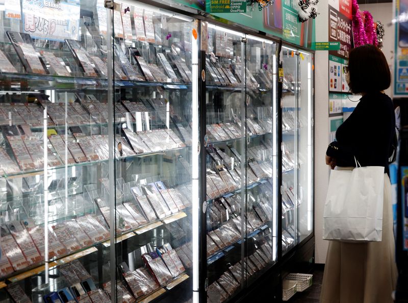 &copy; Reuters. FILE PHOTO-A customer looks at a display of used mobile phones in Iosys Corp's shop selling used smartphones at Akihabara electronics district in Tokyo, Japan October 28, 2022. REUTERS/Kim Kyung-Hoon