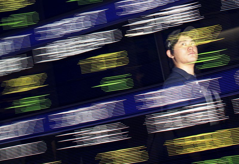 &copy; Reuters. FILE PHOTO: A man is reflected on a display showing stock quotation board outside a brokerage in Tokyo August 25, 2015.  REUTERS/Issei Kato