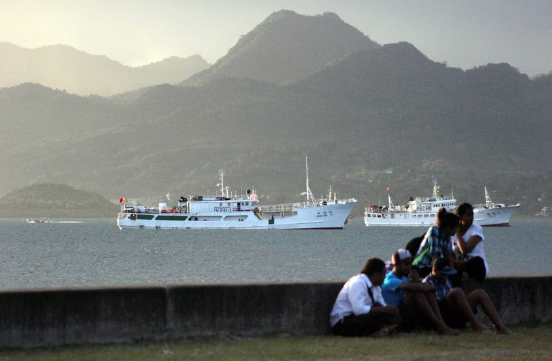 &copy; Reuters. Photo d'archives : Des habitants sont assis sur un mur du port de Suva, la capitale des Fidji. /Photo prise le 24 août 2014/REUTERS/REUTERS/Lincoln Feast
