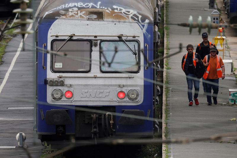 &copy; Reuters. Photo d'archives: Des travailleurs passent devant des trains régionaux TER au dépôt SNCF d'Hellemmes-Lille. /Photo prise le 17 octobre 2022/REUTERS/Pascal Rossignol