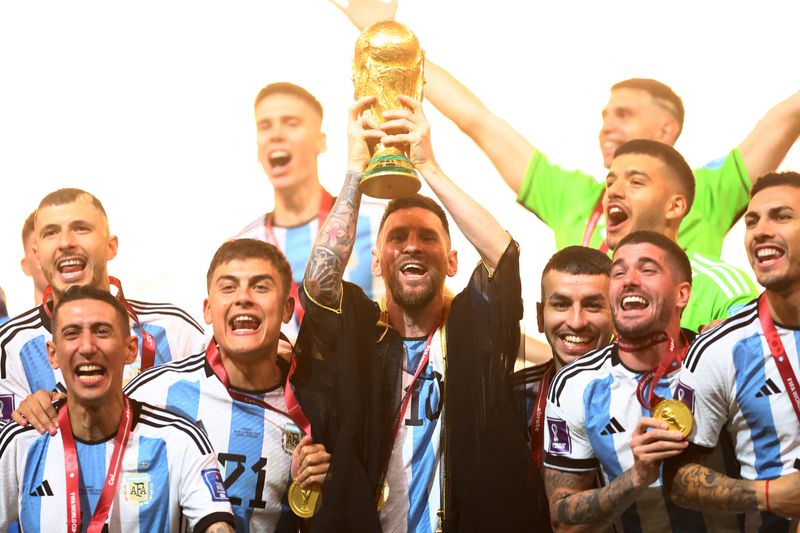 &copy; Reuters. ميسي قائد منتخب الأرجنتين يرفع كأس العالم لكرة القدم 2022 بقطر  ويحتفل مع لاعبي فريقه بعد فوزه على منتخب فرنسا في النهائي في 18 ديسمبر كانون الأ