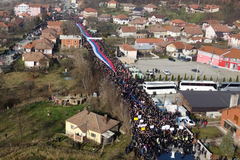 © Reuters. أشخاص من الصرب يحملون علم صربي عملاق خلال احتجاجهم على الحكومة بالقرب من احد الحواجز على الطريق في روداري يوم الخميس. تصوير: فاتوس بايوتيتشي - رويترز