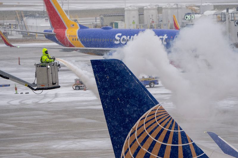 © Reuters. Ice is removed from a United Airlines jet after a cold weather front moved into General Mitchell International Airport in Milwaukee, Wisconsin, U.S. December 22, 2022.  Mark Hoffman/USA Today Network via REUTERS.  NO RESALES. NO ARCHIVES MANDATORY CREDIT