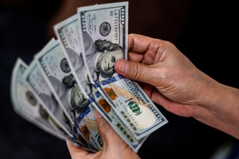 © Reuters. FILE PHOTO: A person shows U.S. dollars at a currency exchange store in Manila, Philippines, October 21, 2022. REUTERS/Lisa Marie David