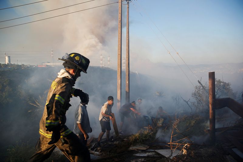 &copy; Reuters. Residentes recogen escombros entre los restos de una casa quemada durante un incendio forestal en Viña del Mar, Chile. Diciembre 22, 2022. REUTERS/Rodrigo Garrido