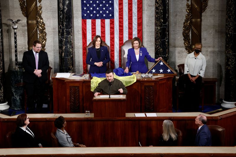 © Reuters. Ukraine's President Volodymyr Zelenskiy addresses a joint meeting of the U.S. Congress while U.S. House Speaker Nancy Pelosi (D-CA) and U.S. Vice President Kamala Harris look on, as a U.S. flag and Ukrainian flag are pictured on the table, in the House Chamber of the U.S. Capitol in Washington, U.S., December 21, 2022. REUTERS/Evelyn Hockstein