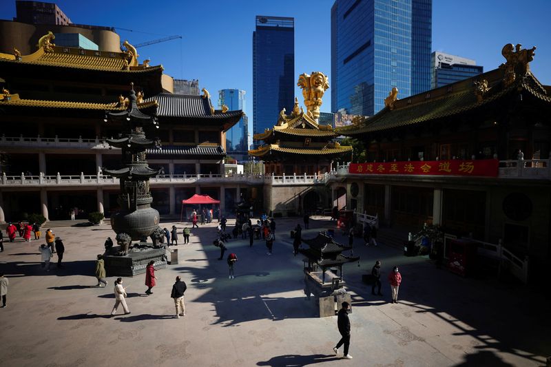 &copy; Reuters. Personas con mascarillas rinden culto en el templo budista de Jing'an, mientras continúan los brotes de COVID-19 en Shanghái, China. 23 de diciembre, 2022. REUTERS/Aly Song