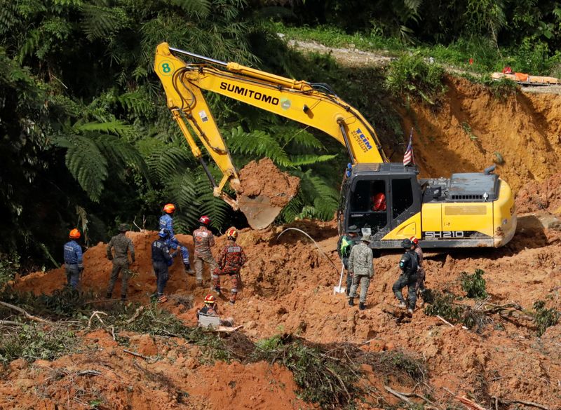 &copy; Reuters. أفراد إنقاذ يعملون أثناء عملية الإنقاذ والإخلاء في أعقاب الانهيار الأرضي في موقع تخييم في باتانج كالي في سيلانجور بماليزيا يوم 17 ديسمبر كان