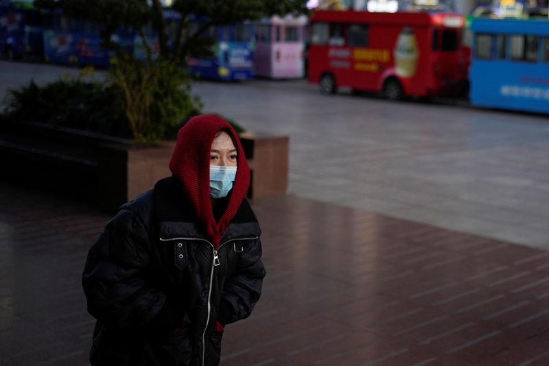 &copy; Reuters. امرأة تضع كمامة تسير في أحد شوارع شنغهاي يوم 23 ديسمبر كانون الأول 2022. تصوير: آلي سونغ - رويترز