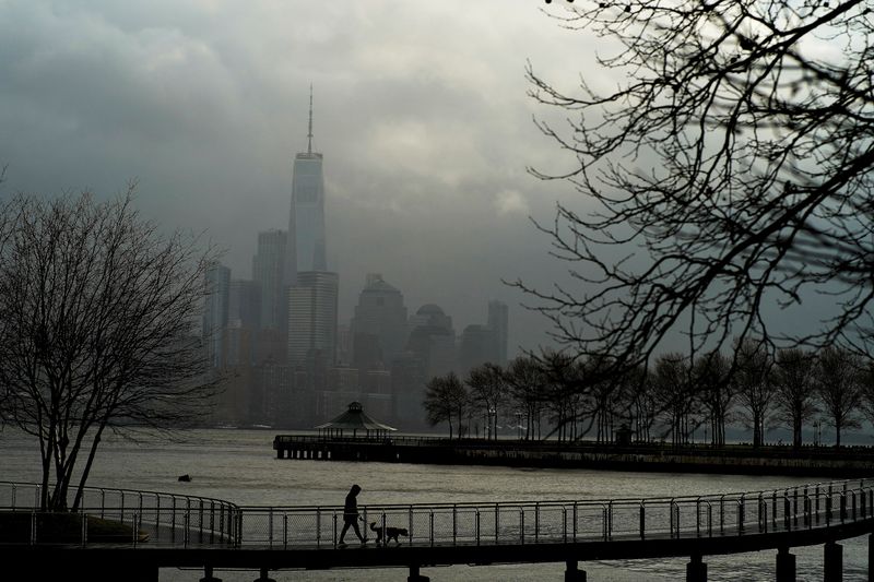 &copy; Reuters. FILE PHOTO: A woman walks her dog in a local park in Hoboken, New Jersey, while storm clouds pass by the One World Trade Center in New York, U.S., December 23, 2022. REUTERS/Eduardo Munoz