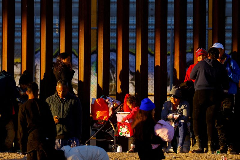&copy; Reuters. Una niña migrante sostiene un regalo de Navidad mientras hace fila con su familia cerca del muro fronterizo para solicitar asilo en El Paso, Texas, EEUU, vista desde Ciudad Juárez, México, el 25 de diciembre de 2022. REUTERS/José Luis González