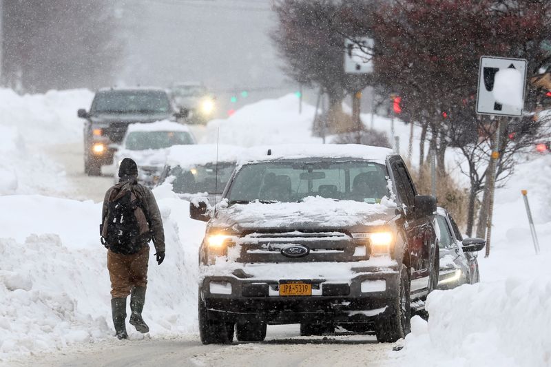 &copy; Reuters. A man walks the street as cars pass by during a winter storm that hit the Buffalo region, in Amherst, New York, U.S., December 26, 2022.  REUTERS/Brendan McDermid