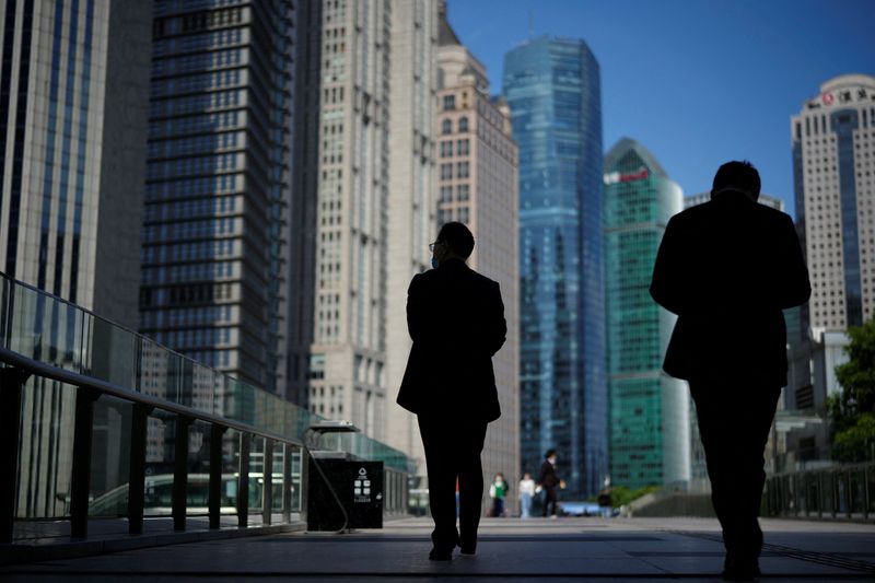 &copy; Reuters. FILE PHOTO: People walk by office towers in the Lujiazui financial district of Shanghai, China October 17, 2022. REUTERS/Aly Song