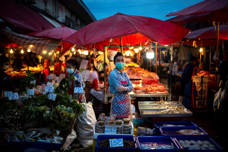 &copy; Reuters. FILE PHOTO: Vendors wearing face masks sell vegetables at a market amid the spread of the coronavirus disease (COVID-19) in Bangkok, Thailand, November 16, 2021. REUTERS/Athit Perawongmetha