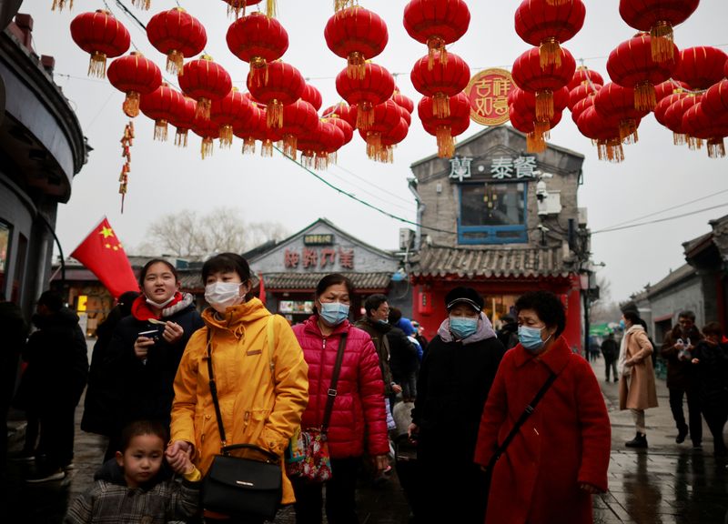 &copy; Reuters. أشخاص يضعون كمامات يسيرون في بكين في صورة من أرشيف رويترز.