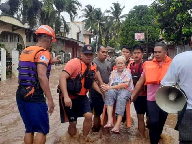 &copy; Reuters. عمال الإنقاذ يساعدون أحد السكان المتضررين من الفيضانات في إقليم ميساميس بالفلبين يوم الاثنين. (يحظر إعادة بيع الصورة أو وضعها في أرشيف).