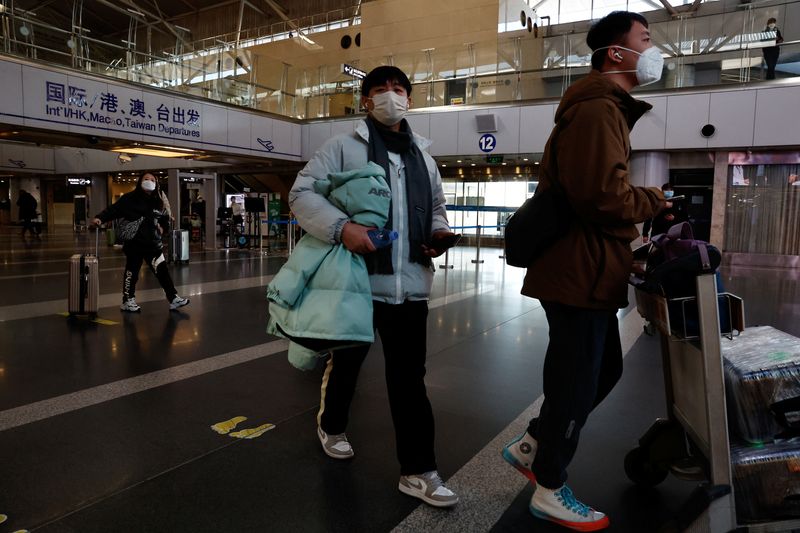 &copy; Reuters. مسافران يمشيان بأمتعتهما في مطار العاصمة بكين الدولي يوم الثلاثاء. تصوير: تينغشو وانغ - رويترز.