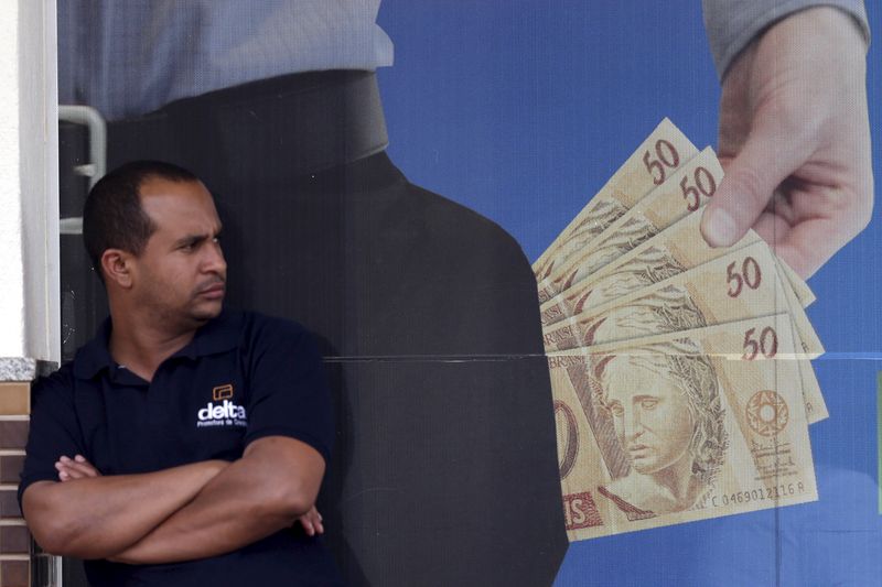 &copy; Reuters. FOTO DE ARCHIVO: Un hombre está de pie frente a una firma de préstamos financieros en el centro de Brasilia