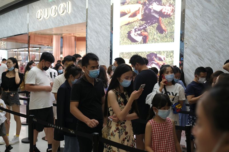 &copy; Reuters. FOTO DE ARCHIVO: Clientes con mascarillas, tras el brote de COVID-19, hacen fila para entrar en una tienda de Gucci en el Sanya International Duty-Free Shopping Complex, en Sanya