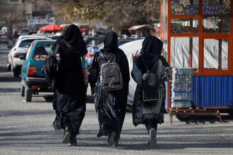 &copy; Reuters. FILE PHOTO: Afghan female students walk near Kabul University in Kabul, Afghanistan, December 21, 2022. REUTERS/Ali Khara