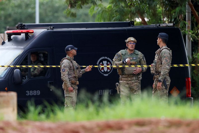 &copy; Reuters. Members of the security forces stand near a cordoned off area following a suspected bomb threat in the city's hotel section, close to where President-elect Luiz Inacio Lula da Silva is staying before his Jan. 1 inauguration, according to the federal di