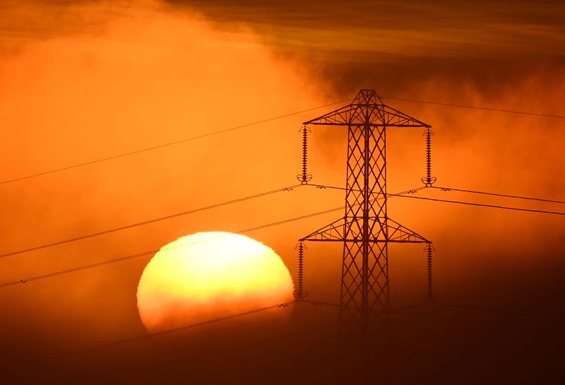 &copy; Reuters. FILE PHOTO: The sun sets behind an electricity pylon, as fog develops, near Petersfield, Britain, December 1, 2022. REUTERS/Toby Melville