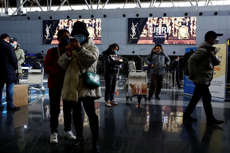 &copy; Reuters. FILE PHOTO: Travellers stand by their luggage at Beijing Capital International Airport, amid the coronavirus disease (COVID-19) outbreak in Beijing, China December 27, 2022. REUTERS/Tingshu Wang