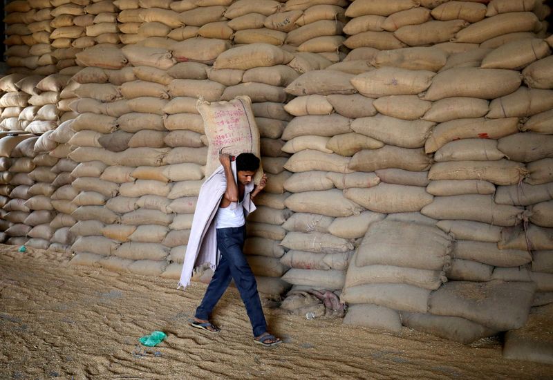 © Reuters. FILE PHOTO: A worker carries a sack of wheat for sifting at a grain mill on the outskirts of Ahmedabad, India, May 16, 2022. REUTERS/Amit Dave/