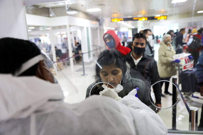 &copy; Reuters. インド政府は、中国、香港、日本、韓国、シンガポール、タイからの渡航者について、１月１日から新型コロナウイルスの陰性証明の提示を求めると発表した。ニューデリーの国際空港での