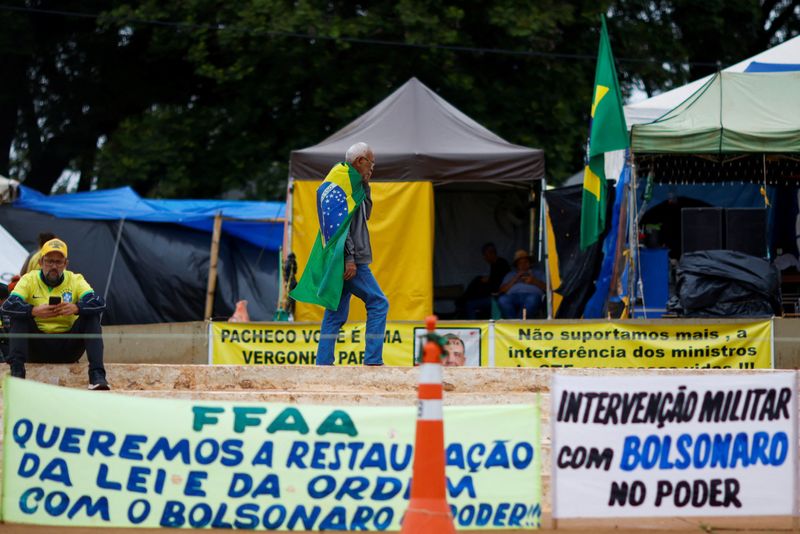&copy; Reuters. FOTO DE ARCHIVO: Un partidario del presidente de Brasil, Jair Bolsonaro, camina frente a las tiendas de campaña de un campamento durante una protesta contra el presidente electo Luiz Inácio Lula da Silva, que ganó un tercer mandato tras la segunda vuel