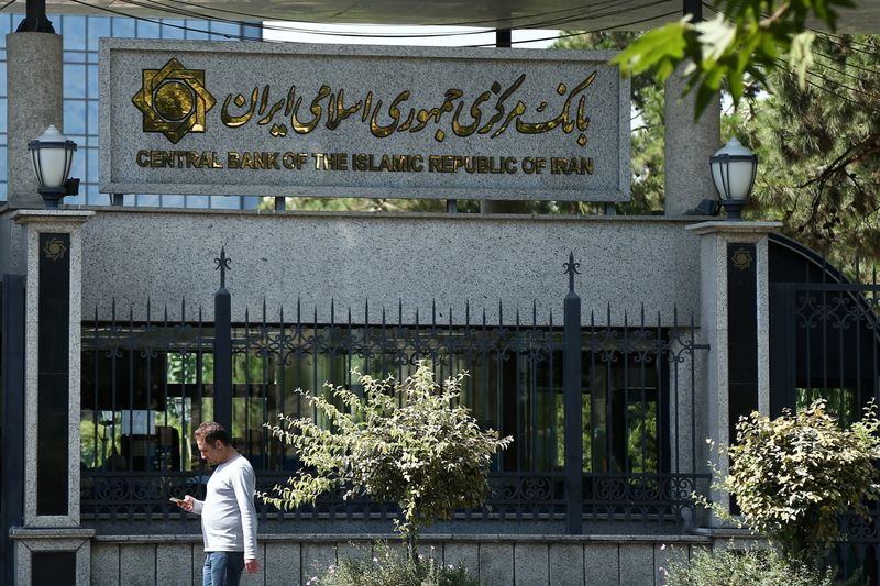 © Reuters. رجل يسير أمام البنك المركزي الإيراني في طهران في صورة من أرشيف رويترز.
