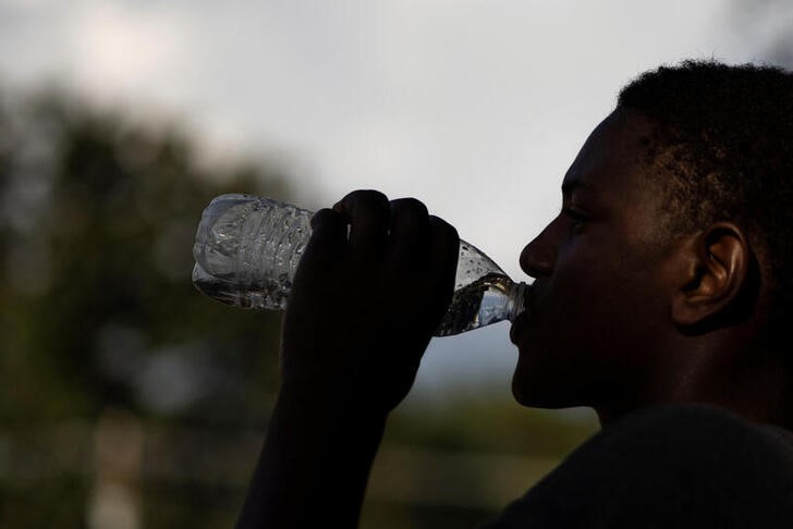 © Reuters. A volunteer drinks water during a break at a water distribution site as the city of Jackson is to go without reliable drinking water indefinitely after the water treatment plant pumps failed, leading to the emergency distribution of bottled water and tanker trucks for 180,000 people, in Jackson, Mississippi, U.S., September 2, 2022. REUTERS/Carlos Barria
