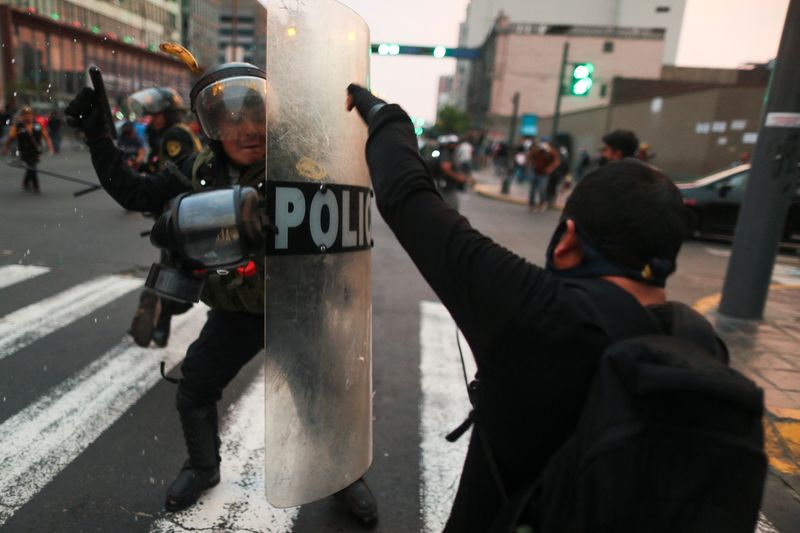 &copy; Reuters. Manifestantes chocan con la policía antidisturbios durante una protesta exigiendo elecciones presidenciales y el cierre del Congreso después de que el mandatario peruano Pedro Castillo fue destituido y detenido en una prisión policial, en Lima, Perú, 