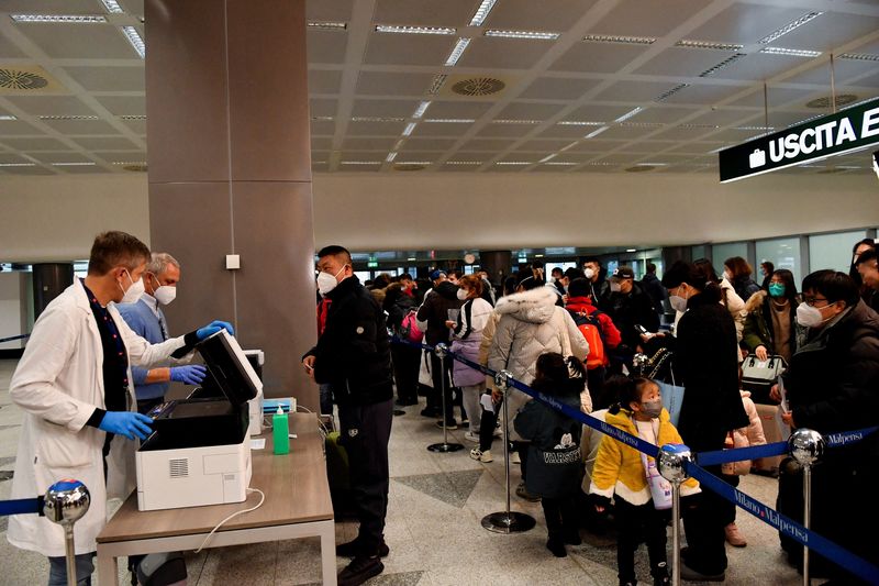 &copy; Reuters. Pasajeros esperan en una cola, después de que Italia haya ordenado hisopos con antígeno de la enfermedad por coronavirus (COVID-19) y secuenciación del virus para todos los viajeros procedentes de China, donde están aumentando los casos, en el aeropue