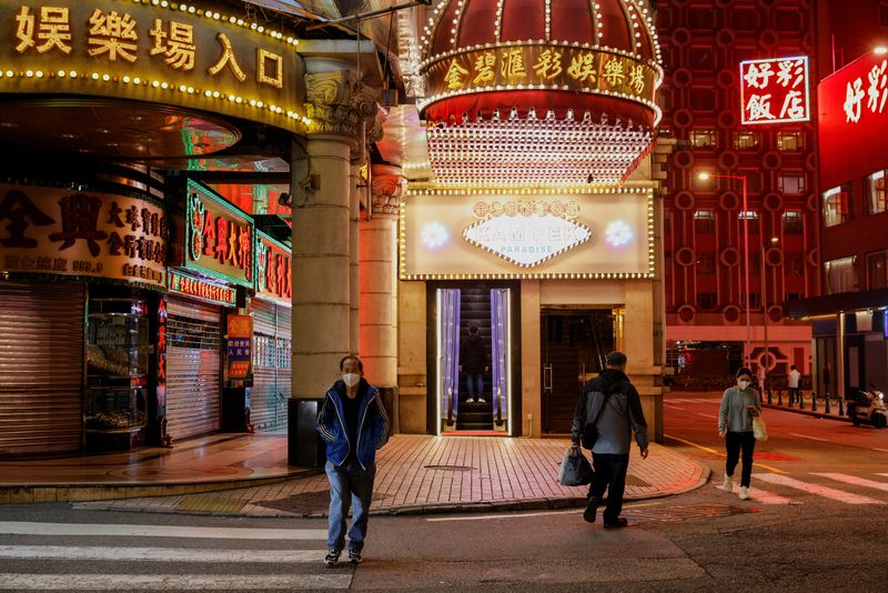 &copy; Reuters. People wearing face masks walk under neon lights near casinos during the coronavirus disease (COVID-19) pandemic in Macau, China, December 29, 2022. REUTERS/Tyrone Siu