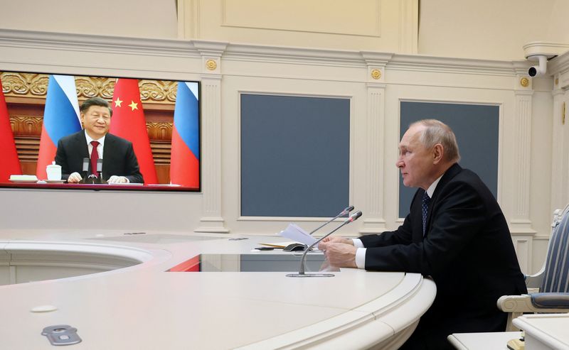 © Reuters. ロシアのプーチン大統領は３０日、中国の習近平国家主席とビデオ会談を行い、来春に習氏がロシアを公式訪問し軍事協力を深化することに期待を示した。提供写真。（2022年　ロイター/Sputnik/Mikhail Kuravlev/Kremlin）