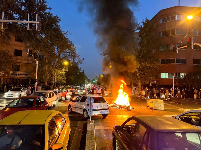 © Reuters. FILE PHOTO: A police motorcycle burns during a protest over the death of Mahsa Amini, a woman who died after being arrested by the Islamic republic's 