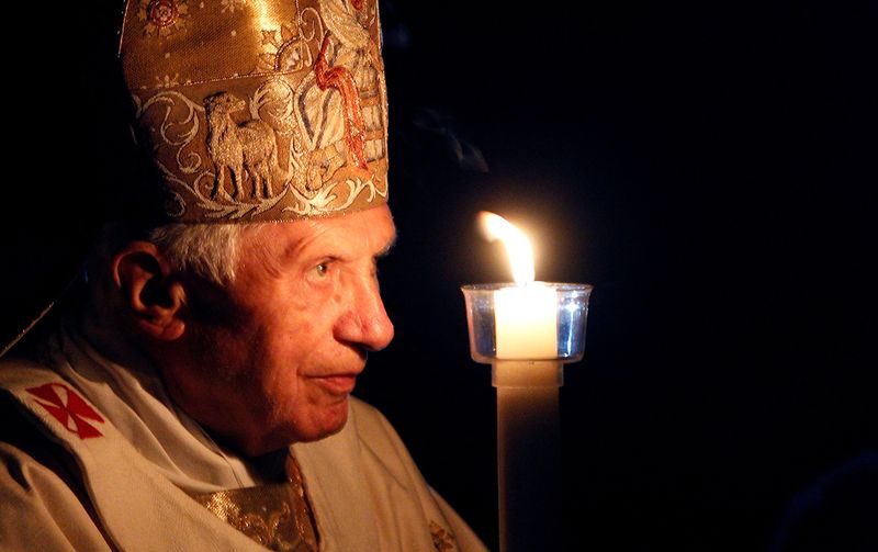 &copy; Reuters. بابا الفاتيكان السابق بنديكت السادس عشر يحمل شمعة لدى وصوله لقيادة قداس في الفاتيكان عام 2012. الصورة من أرشيف رويترز 
