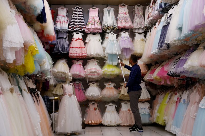 &copy; Reuters. صاحب متجر يعرض ملابس أطفال في متجره بمدينة إسطنبول التركية في صورة من أرشيف رويترز.