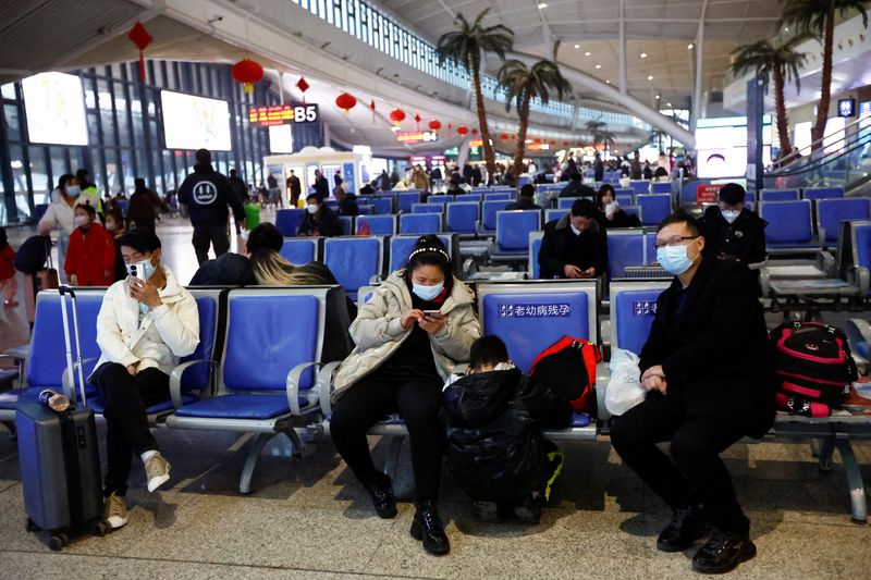 © Reuters. People wait with their luggages at a railway station, amid the coronavirus disease (COVID-19) outbreak, in Wuhan, Hubei province, China January 1, 2023. REUTERS/Tingshu Wang