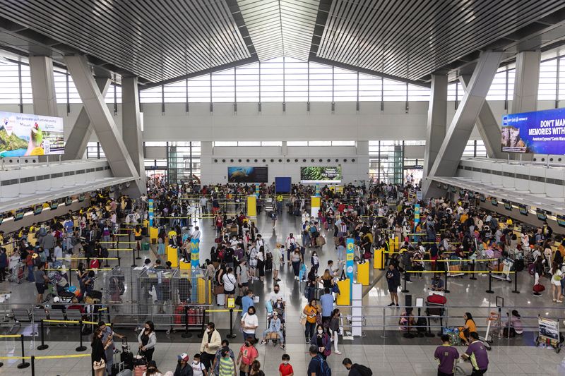 © Reuters. Passengers queue at airline counters in the Ninoy Aquino International Airport, in Pasay City, Metro Manila, Philippines, January 2, 2023. REUTERS/Eloisa Lopez
