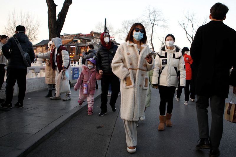 &copy; Reuters. أشخاص يضعون كمامات يسيرون في الشارع في بكين يوم 31 ديسمبر كانون الأول 2022. تصوير: فلورنس لو - رويترز.