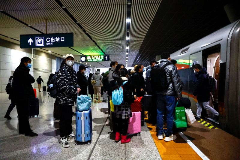 &copy; Reuters. Diversi turisti salgono su un treno a una stazione ferroviaria di Wuhan, nella provincia di Hubei, in Cina. REUTERS/Tingshu Wang