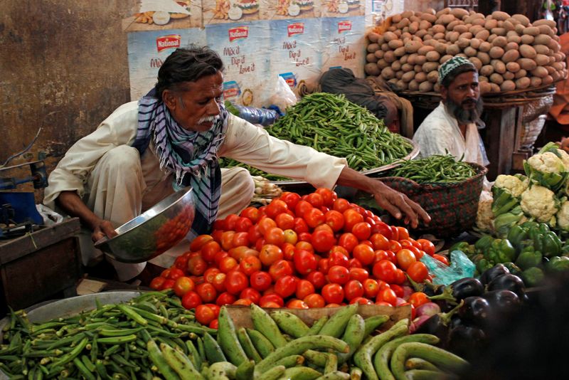 &copy; Reuters. FILE PHOTO: Men sell vegetables at their makeshift stalls at the Empress Market in Karachi, Pakistan April 2, 2018. REUTERS/Akhtar Soomro